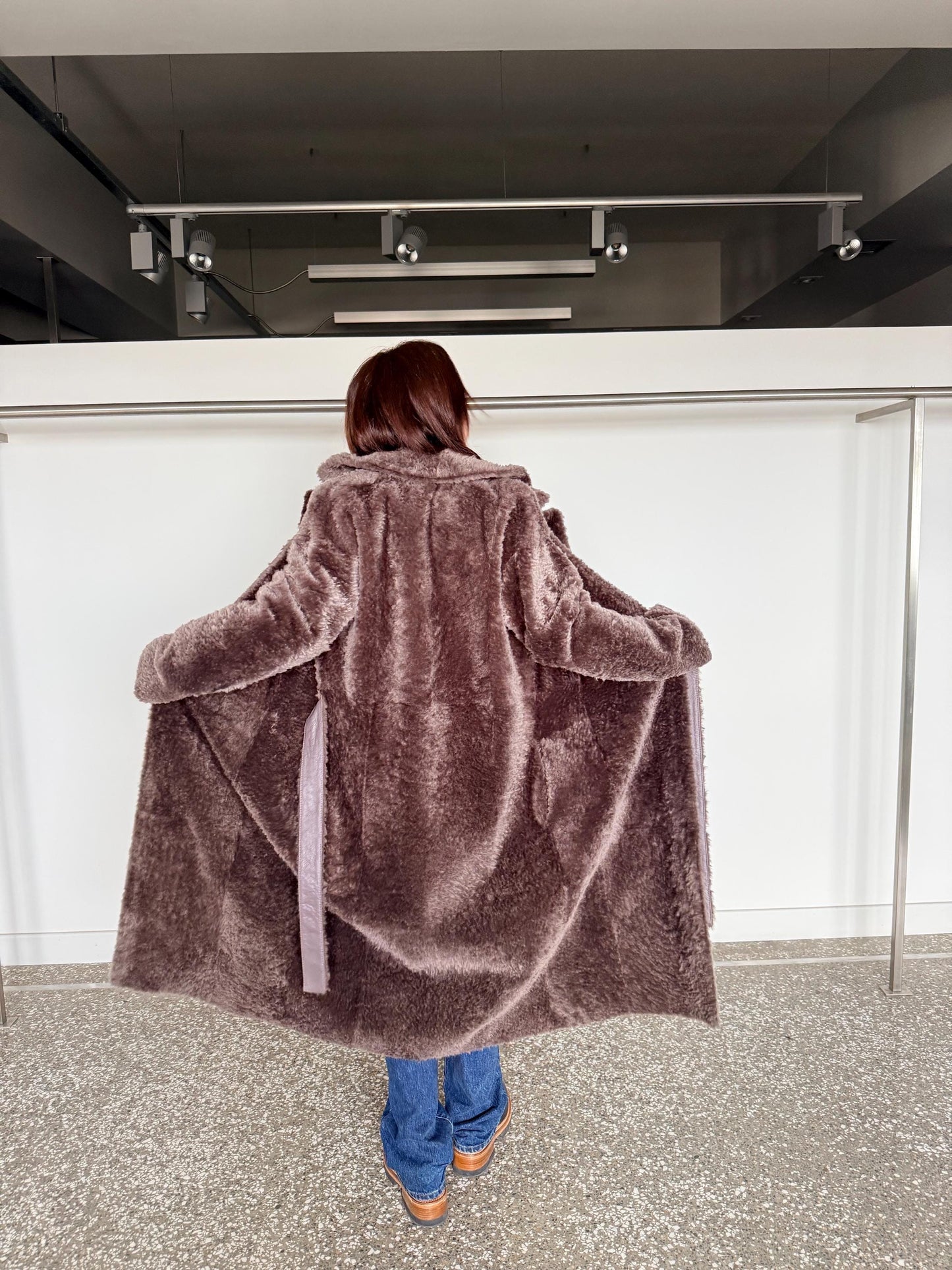 Reversible grayish merino shearling and leather coat: Super warm and soft brown Sheepskin stroller with tie belt closure.