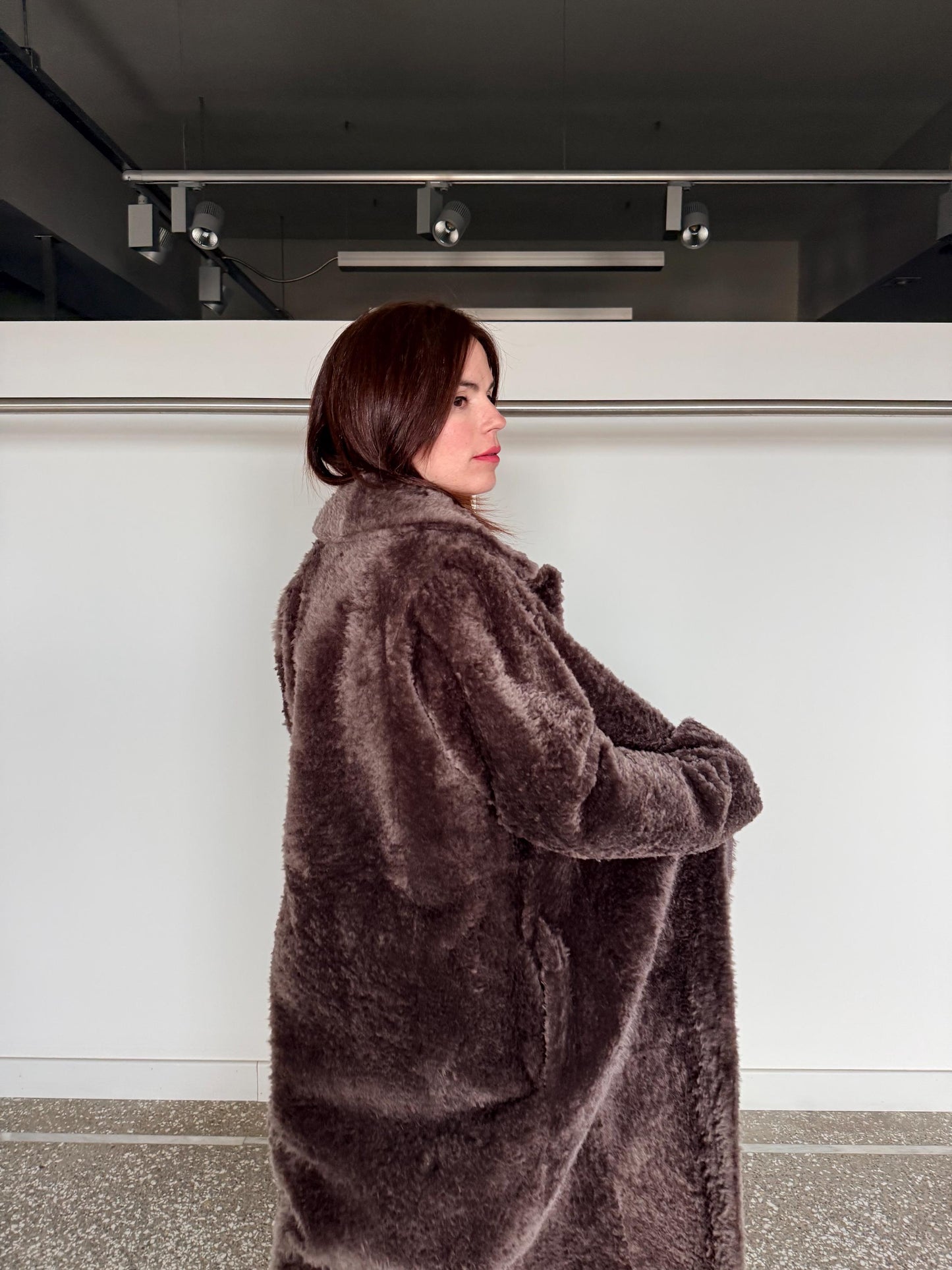 Reversible grayish merino shearling and leather coat: Super warm and soft brown Sheepskin stroller with tie belt closure.