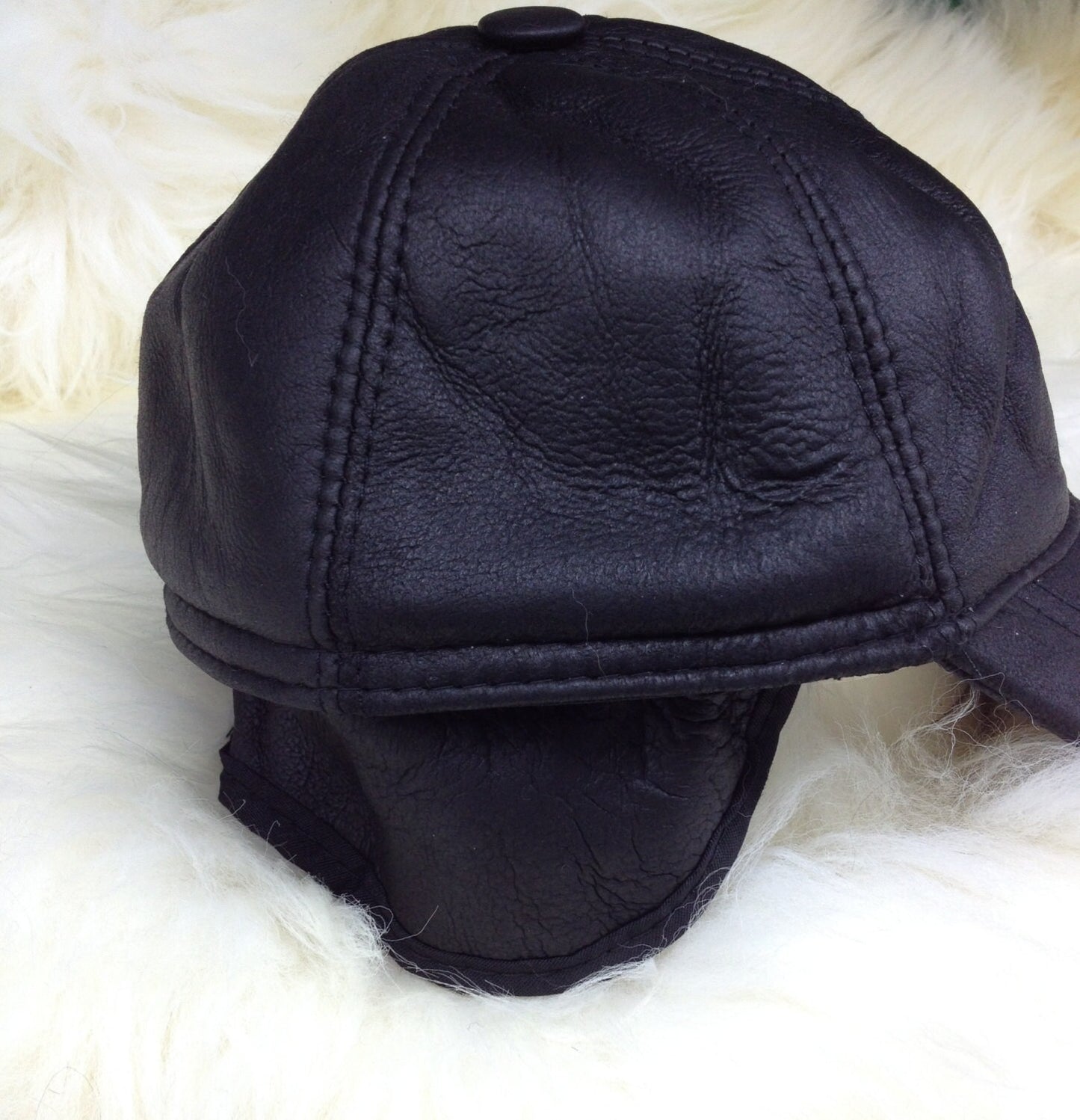 Real shearling - leather cap with ears and fur inside.