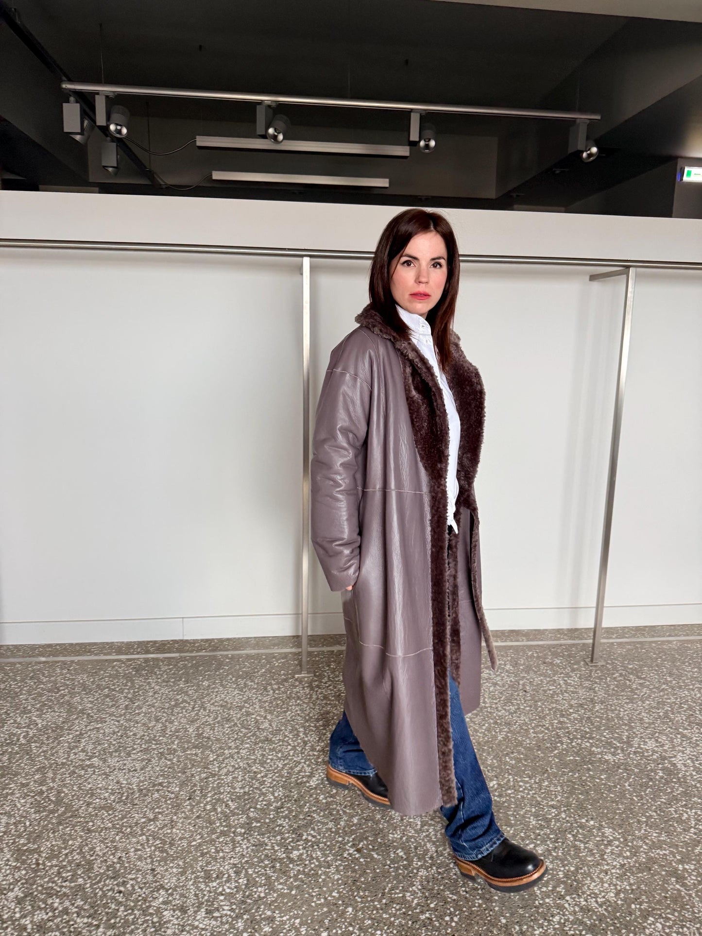 Reversible grayish merino shearling and leather coat: Super warm and soft brown Sheepskin stroller with tie belt closure.
