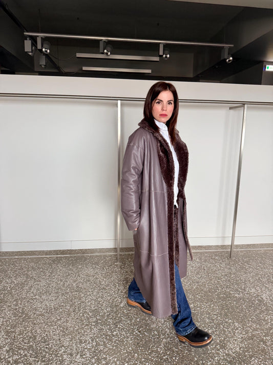 Reversible grayish merino shearling and leather coat: Super warm and soft brown Sheepskin stroller with tie belt closure.