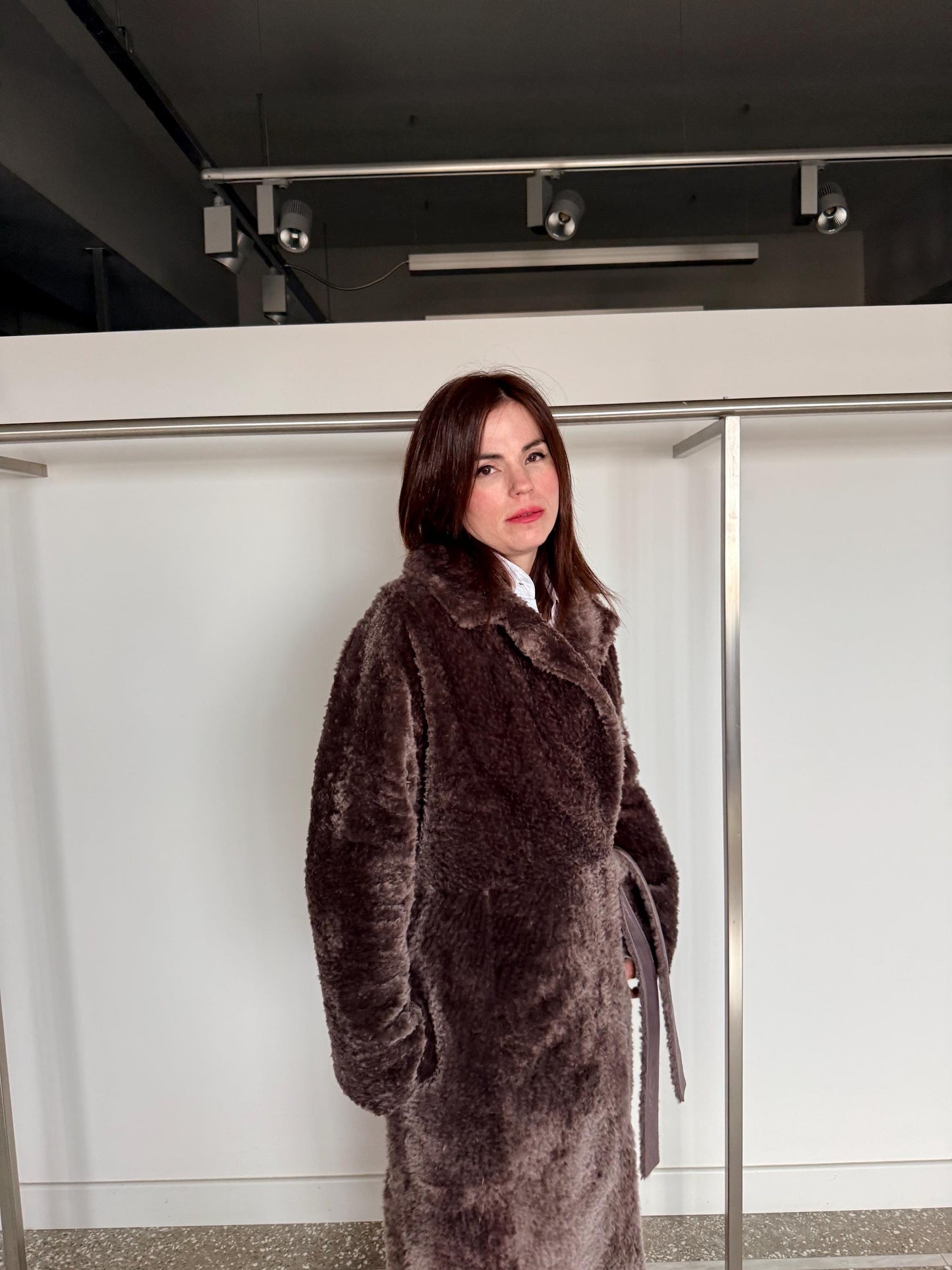 Reversible grayish merino shearling and leather coat: Super warm and soft brown Sheepskin stroller with tie belt closure.