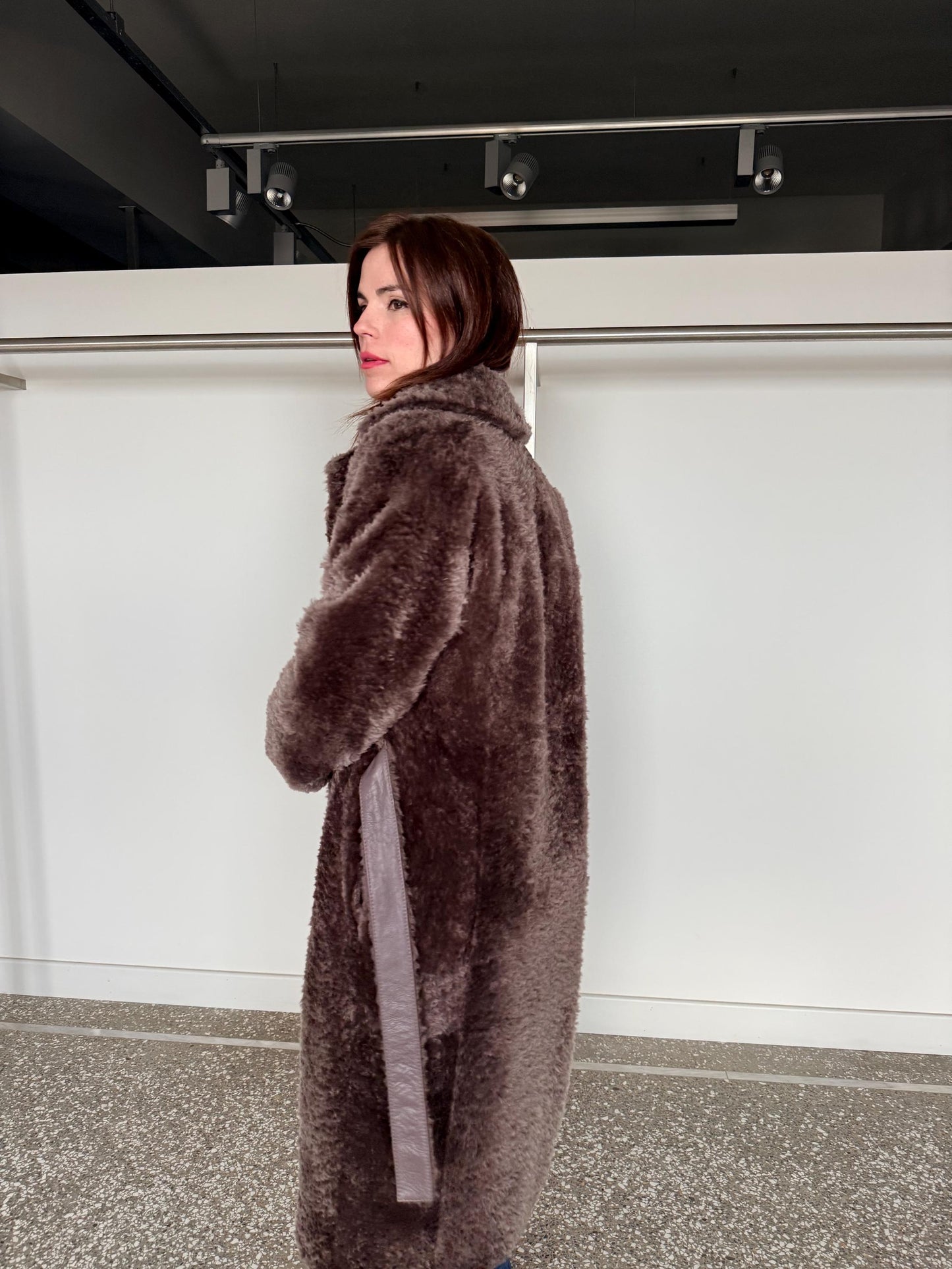 Reversible grayish merino shearling and leather coat: Super warm and soft brown Sheepskin stroller with tie belt closure.