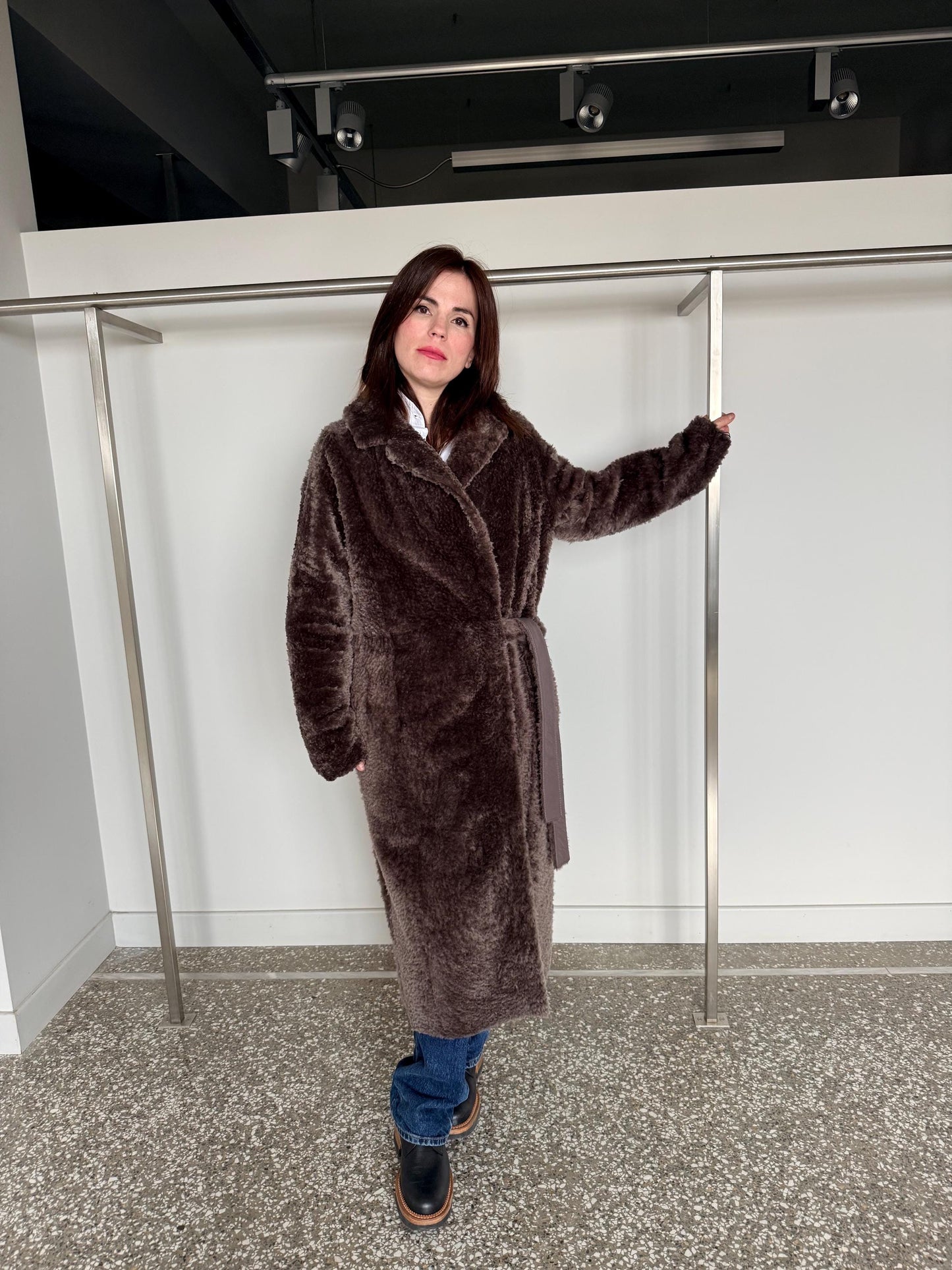 Reversible grayish merino shearling and leather coat: Super warm and soft brown Sheepskin stroller with tie belt closure.